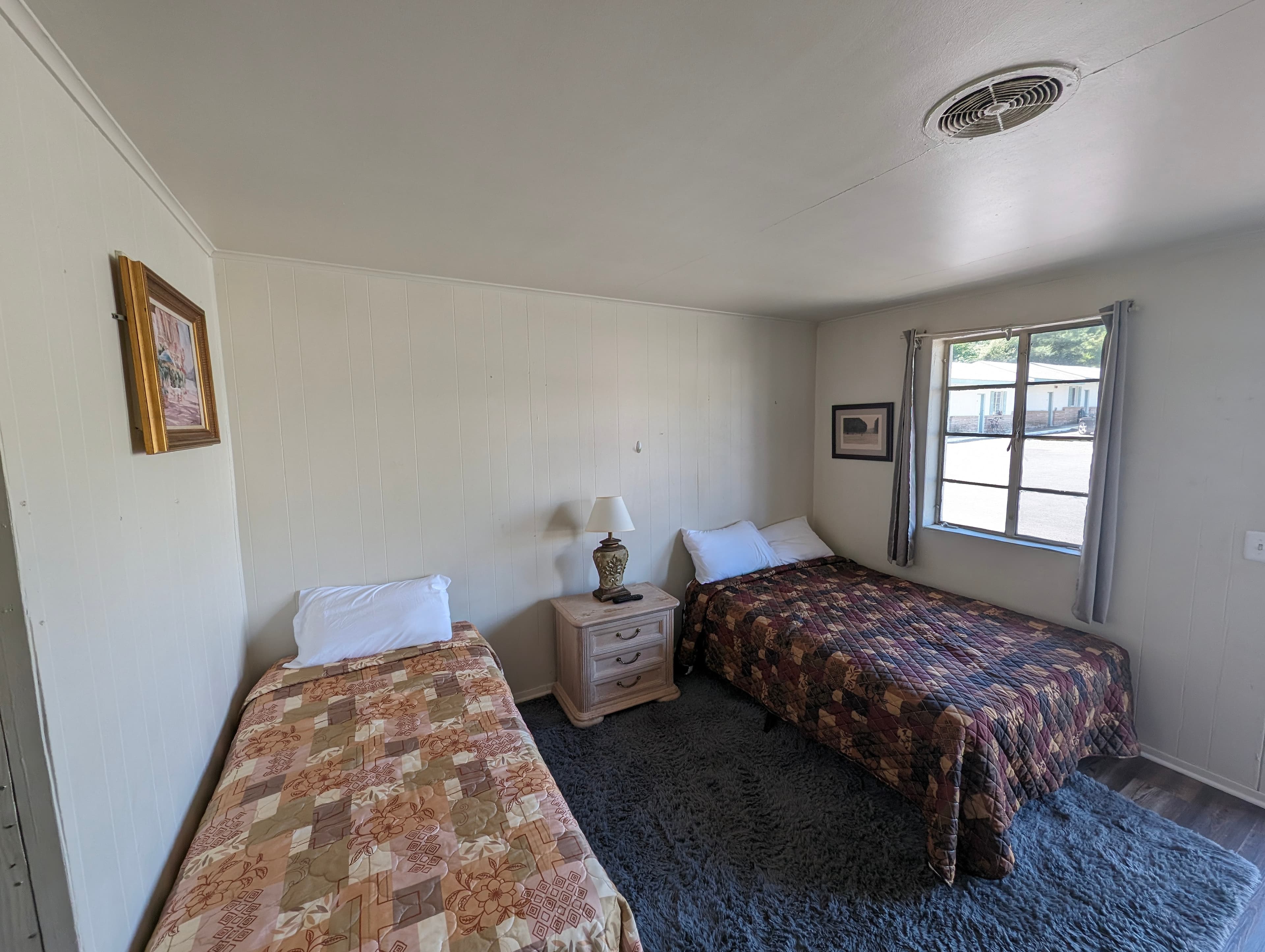 Standard room with one double bed and patterned quilt