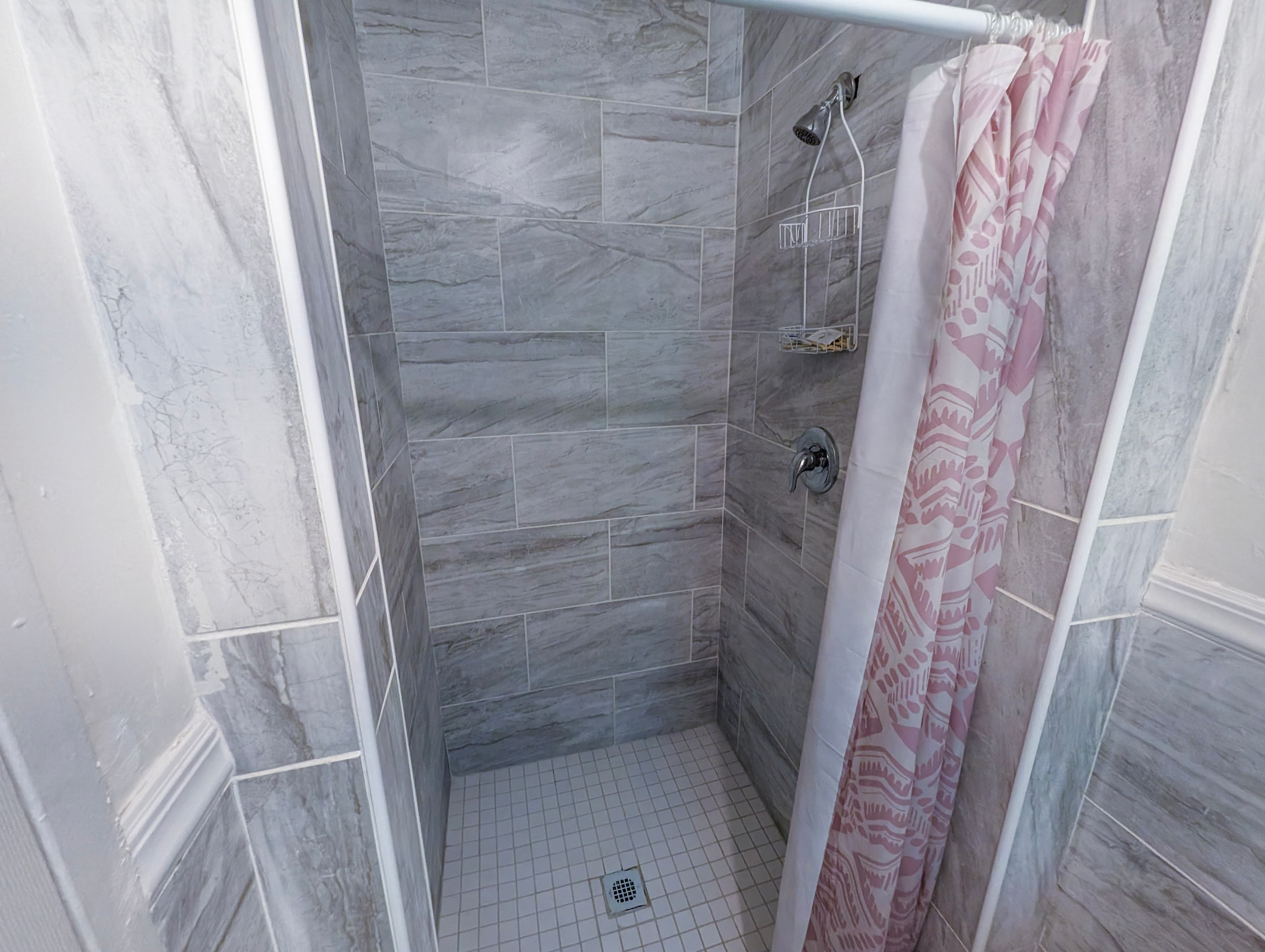 Private tiled shower with marble-look tile
