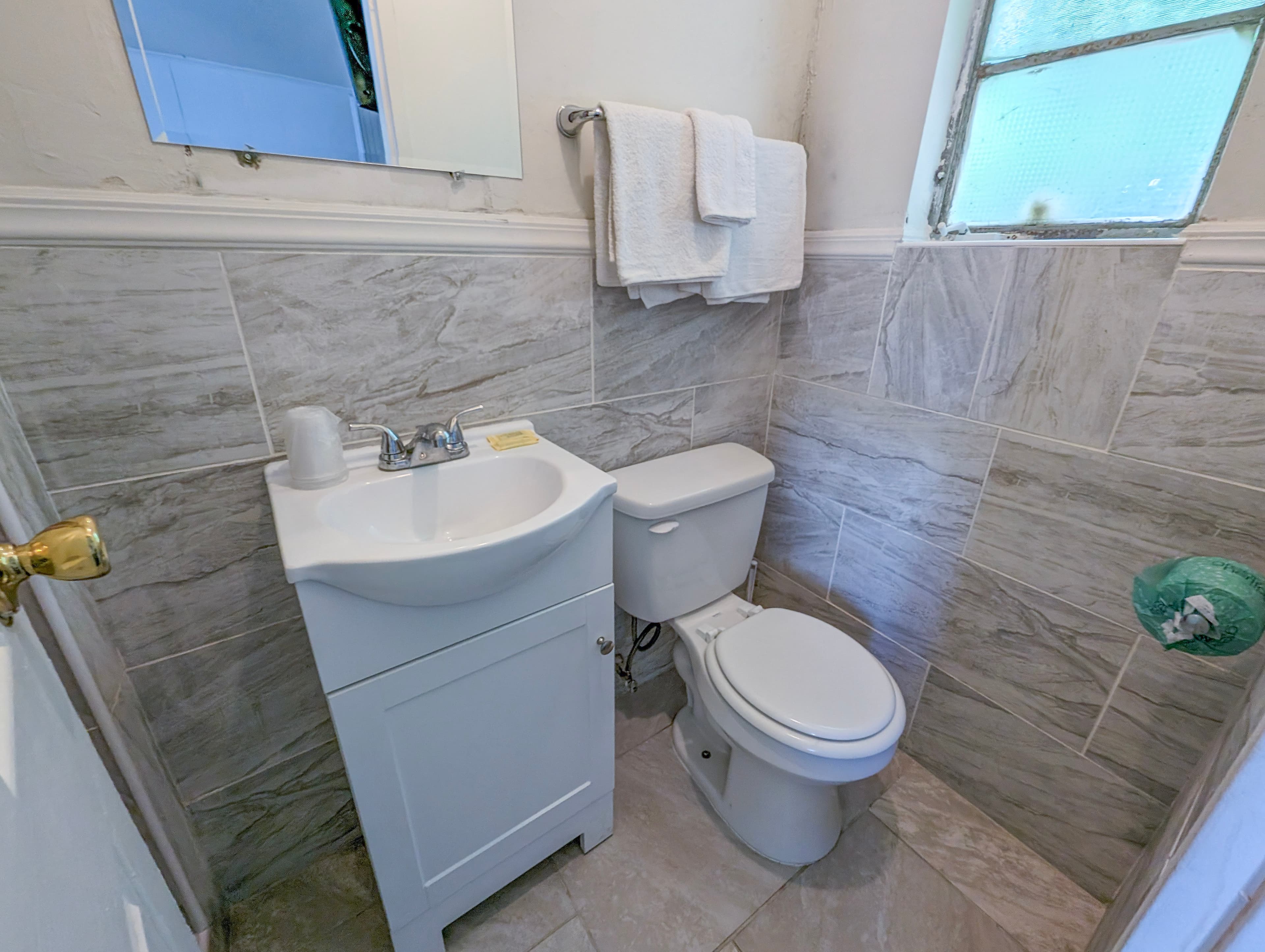 Updated private bathroom with marble tile and fresh towels